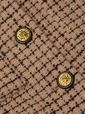 Close-up of the Jia Cropped Tweed Jacket in tan textured tweed with a checkered pattern, two gold embossed decorative buttons with black trim, shown on overlapping fabric panels.