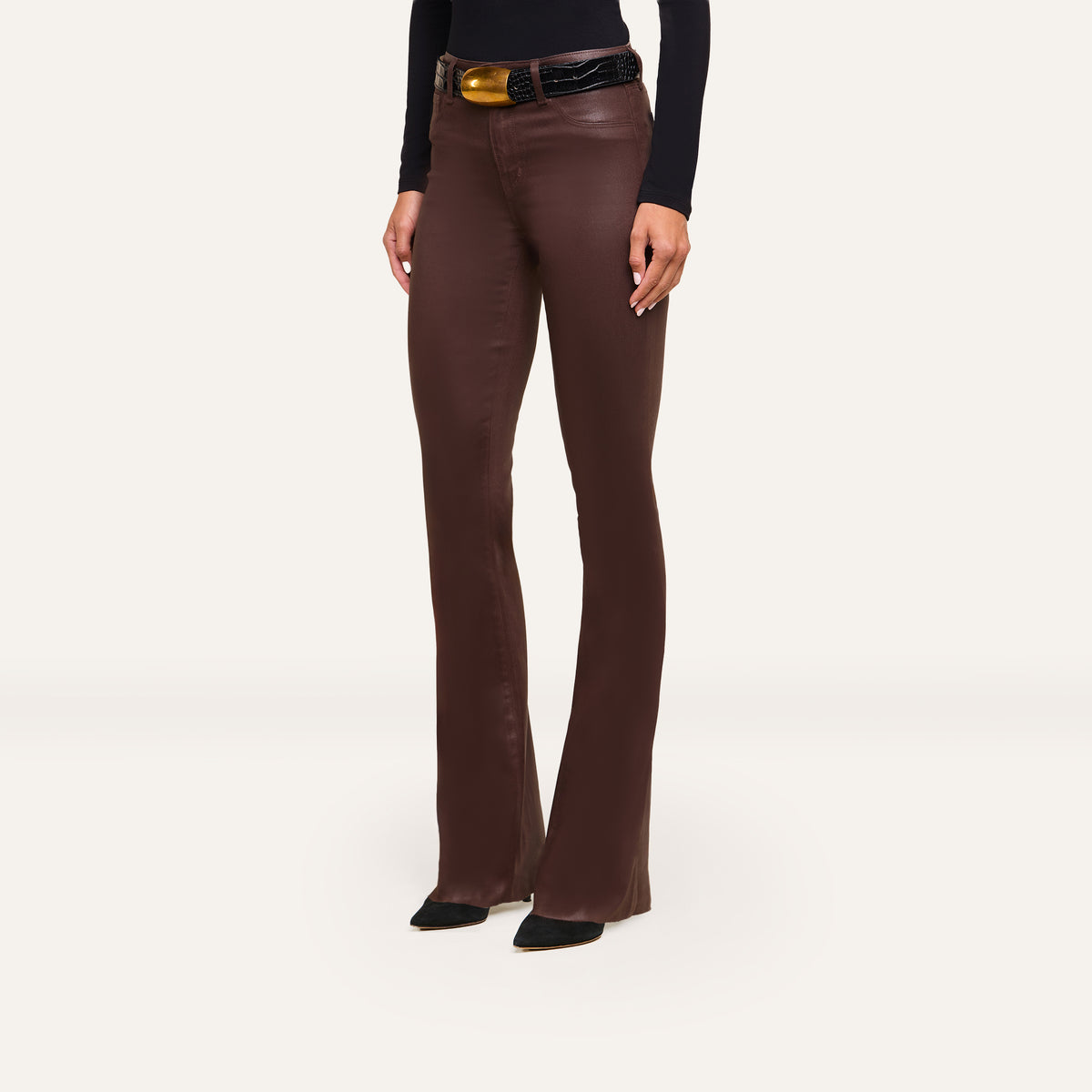 A person wearing Ruth Coated Straight-Leg Jean high-rise, coated stretch denim jeans with a black belt and pointed-toe black shoes.