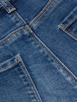 Close-up of the Cara Low-Rise Bootcut Jean by L'AGENCE, showcasing blue stretch denim with highlighted back pockets, defined seams, and signature orange stitching.
