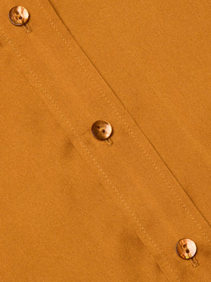Close-up of the Dani Silk Blouse by L'AGENCE shows brown silk fabric with a seam and three marbled buttons sewn vertically. The material’s texture and stitching are clearly visible.