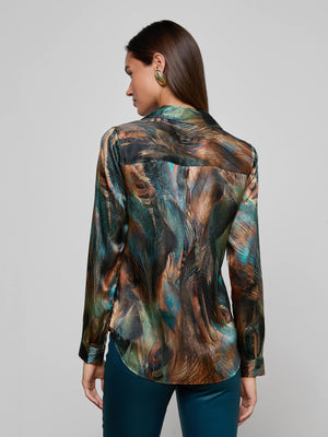 A woman with long brown hair wears the L'AGENCE Tyler Silk Blouse with a feather print and green earrings, shown from the back against a plain light gray background.