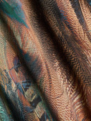 Close-up of the Seridie Silk Slip Dress by L'AGENCE, featuring a vibrant teal feather print in shades of brown, orange, black, and teal—perfect for a bias-cut style that mimics overlapping feathers.