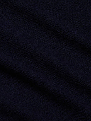 Close-up of the Kolie Chain Top in dark navy blue textured fabric with soft folds and a slightly fuzzy surface, suggesting a warm, cozy feel—perfect for this V-neckline knit style.