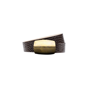 The Milou Belt, featuring brown croc-embossed leather and a large rectangular brass buckle, is coiled on a plain white background.