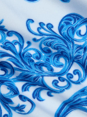 Close-up of the Gianna Brazilian Bikini Bottom's white fabric featuring an intricate blue baroque print with swirling florals and vines for a detailed, decorative look.