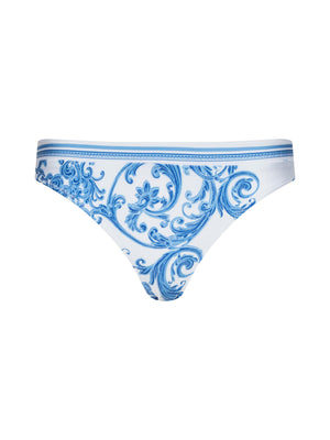 The Gianna Brazilian Bikini Bottom in white features an intricate blue baroque-style floral pattern, displayed against a plain white background.