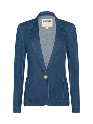 The Baldwin Blazer by L’AGENCE is a single-breasted indigo stretch denim blazer with notched lapel, gold button closure, two front flap pockets, long sleeves, visible stitching, and an interior L’AGENCE label.