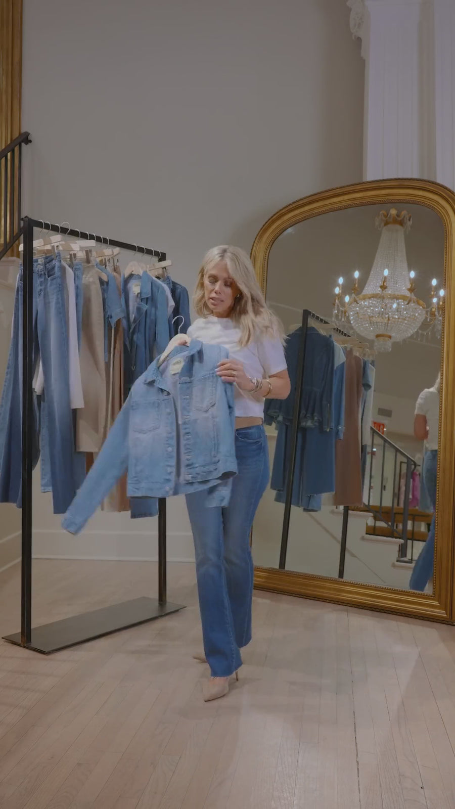 Tara Rudes Dann displaying a denim jean jacket while wearing a white tee and dark wash pants